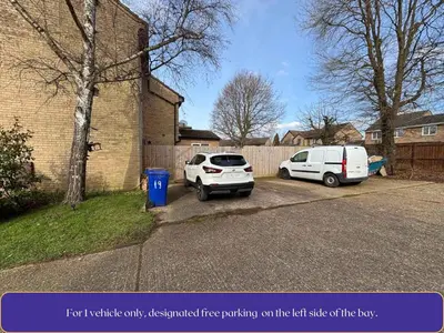 two cars parked in a parking lot next to a building at Cosy 1-Bed Apt in Newmarket with Parking in Newmarket