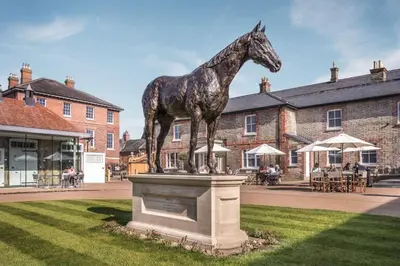 a statue of a giraffe standing on a pedestal in the grass at Cosy 1-Bed Apt in Newmarket with Parking in Newmarket