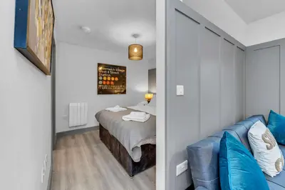 a bedroom with a bed and a blue couch at Cosy 1-Bed Apt in Newmarket with Parking in Newmarket