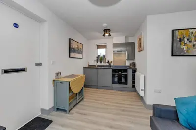 a living room with a kitchen and a couch at Cosy 1-Bed Apt in Newmarket with Parking in Newmarket