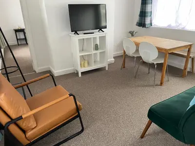 a living room with a tv and a table and chairs at Cambridge Water House Apartments in Cambridge