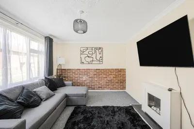 a living room with a couch and a flat screen tv at The House In Defoe Rd - 3br 1bath W Free Parking in Ipswich