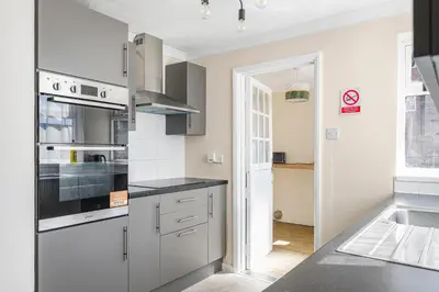a kitchen with a stove top oven next to a sink at The House In Defoe Rd - 3br 1bath W Free Parking in Ipswich