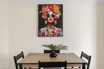 a painting of a woman with sunglasses and flowers at The House In Defoe Rd - 3br 1bath W Free Parking in Ipswich