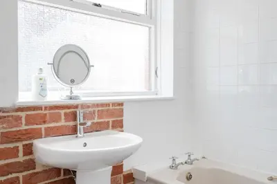 a bathroom with a sink and a mirror on a window at The House In Defoe Rd - 3br 1bath W Free Parking in Ipswich