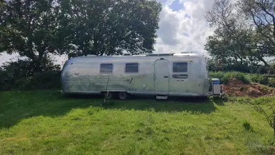 an old trailer parked in a field of grass at Bury - Lodge - Sleeps 2 - Parking in Great Welnetham