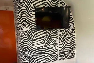 a tv on a wall with a black and white pattern at Bury - Lodge - Sleeps 2 - Parking in Great Welnetham