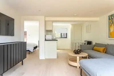 a living room with a couch and a table at Modern self contained one bedroom with garden in Sheering