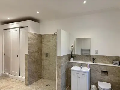 a bathroom with a shower and a toilet and a sink at North Farm fits 1-6 people in Sawston