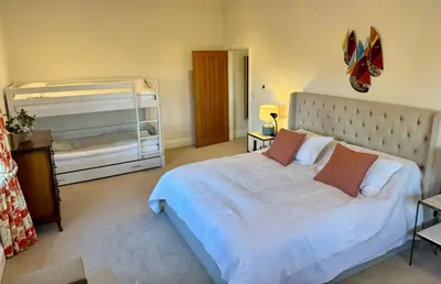a bedroom with a large white bed and a crib at North Farm fits 1-6 people in Sawston