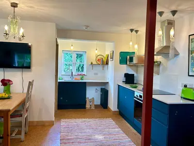 a kitchen with blue cabinets and a dining table at Crown Lodge, Great Glemham in Saxmundham