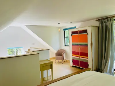 a bedroom with a bed and a colorful door at Crown Lodge, Great Glemham in Saxmundham