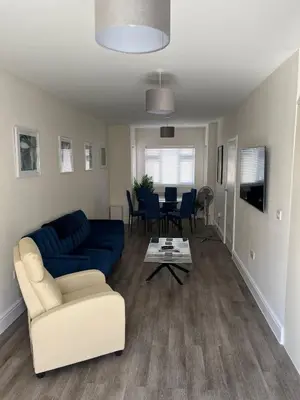 a living room with a blue couch and a table at Seaview House with Sea View Brand New- 3 Bedrooms - Harwich, Dovercourt in Lancing