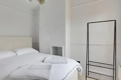 a white bedroom with a white bed and a mirror at Luxury Two Bedroom Cottage - Bishops Stortford in Bishops Stortford