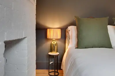 a bedroom with a bed and a lamp on a table at Luxury Two Bedroom Cottage - Bishops Stortford in Bishops Stortford