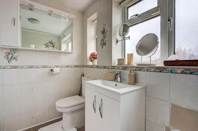 a bathroom with a toilet and a sink and a mirror at Luxury - 4 BHK Semi Detached House in Chelmsford