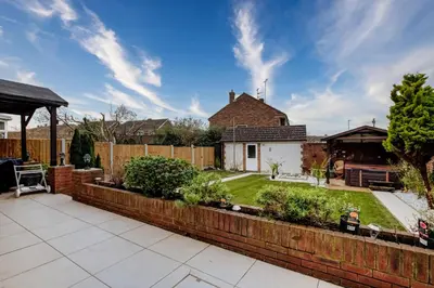 a garden with a brick fence and a house at Luxury - 4 BHK Semi Detached House in Chelmsford