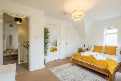a bedroom with a bed with yellow pillows at Next To Park 3 Bedroom V CENTRAL in Cambridge
