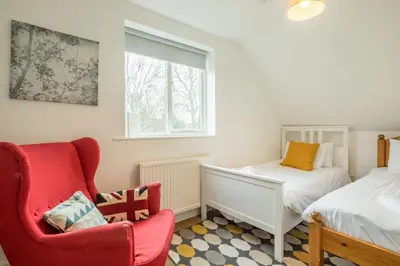a bedroom with a red chair and a bed at Next To Park 3 Bedroom V CENTRAL in Cambridge