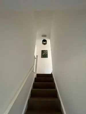 a staircase in a building with a clock on the wall at Next To Park 3 Bedroom V CENTRAL in Cambridge