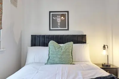 a bed with a green pillow on top of it at 4br 2bath House With Free Parking In Rivenhall in Rivenhall