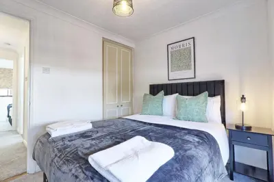 a bedroom with a large bed with two towels on it at 4br 2bath House With Free Parking In Rivenhall in Rivenhall