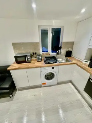 a kitchen with a sink and a washing machine at cozy 1 bedroom flat near cambridge city centre in Milton