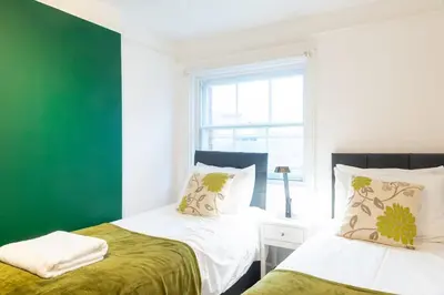 two beds in a room with a green wall at 2br 2bath Flat In Ipswich City Centre - 6 Guests in Ipswich