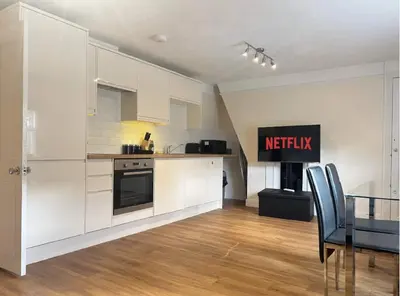a kitchen with white cabinets and a dining table at 2br 2bath Flat In Ipswich City Centre - 6 Guests in Ipswich