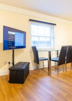 a room with a table and chairs and a flat screen tv at 2br 2bath Flat In Ipswich City Centre - 6 Guests in Ipswich