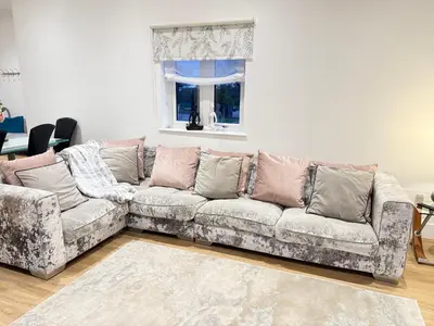 a living room with a couch and a window at Beautiful 2 Bedroom Barn -Stansted Airport 2 miles in Elsenham