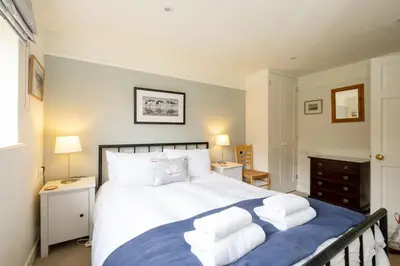 a bedroom with a large bed with towels on it at 8 Lee Road, Aldeburgh - Aldeburgh Coastal Cottages in Aldeburgh