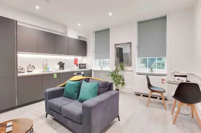 a living room with a couch and a kitchen at Castle Hill Apartments Colchester in Colchester