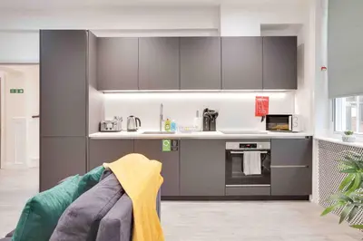 a kitchen with gray cabinets and a stove at Castle Hill Apartments Colchester in Colchester