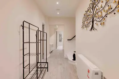 a hallway with a staircase and a painting on the wall at Castle Hill Apartments Colchester in Colchester