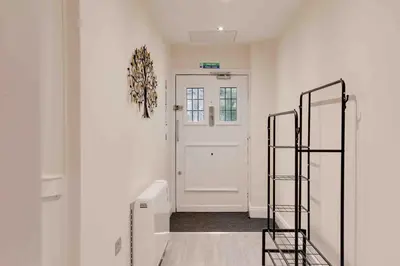 a hallway with a white door and a ladder at Castle Hill Apartments Colchester in Colchester
