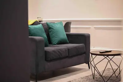 a gray couch with green pillows in a living room at Castle Hill Apartments Colchester in Colchester