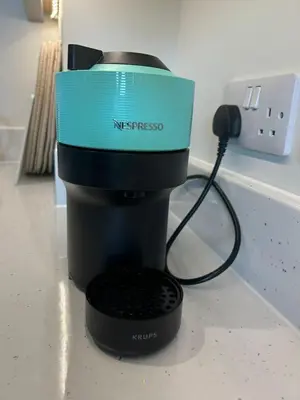 a coffee maker with a blue box on top of it at Mango Cottage in Thorndon