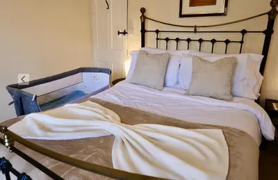 a large bed with white sheets and pillows at Deben Cottage, Central Woodbridge in Woodbridge
