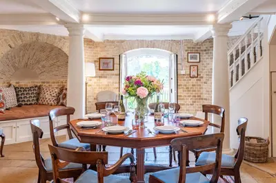 a dining room with a table with a vase of flowers at A Duke's Spectacular grand folly - The Temple in Euston