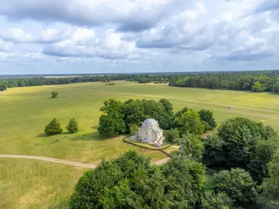 an aerial view of an old building in a field at A Duke's Spectacular grand folly - The Temple in Euston