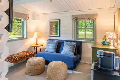 a living room with a blue couch and two windows at A Duke's Spectacular grand folly - The Temple in Euston