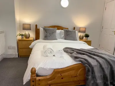 a bedroom with a large bed with towels on it at Luxe city stay in Ipswich