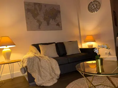 a living room with a couch and a glass table at Luxe city stay in Ipswich