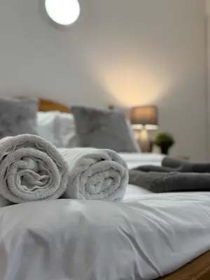 two towels are stacked on top of a bed at Luxe city stay in Ipswich