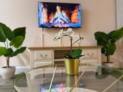 a living room with a glass table and a tv at Luxe city stay in Ipswich