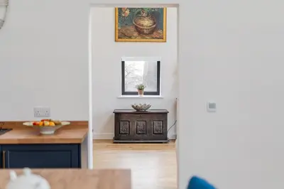 a kitchen with a table and a picture on the wall at The Stable Barn, Smallwood Farm House in Hessett