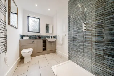a bathroom with a toilet and a glass shower at The Stable Barn, Smallwood Farm House in Hessett