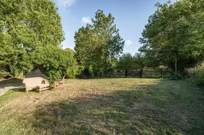 a backyard with a bench and a fence at The Stable Barn, Smallwood Farm House in Hessett