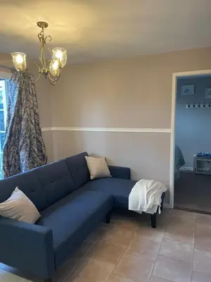 a blue couch in a living room with a window at Be Our Guest in Earls Colne